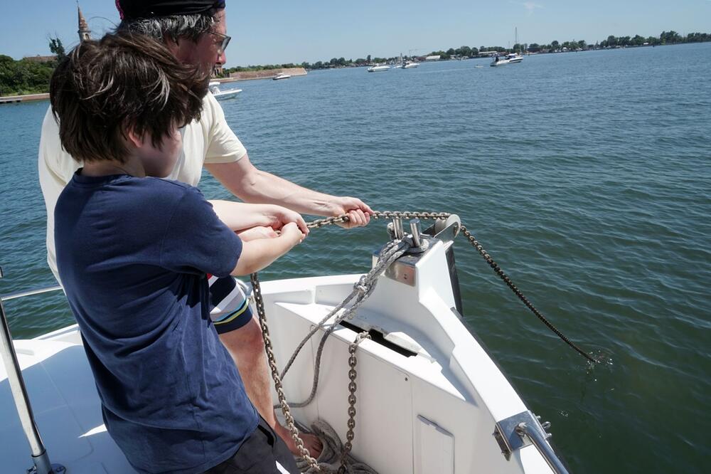 Vater und Sohn beim Anker lichten vor der Isola Poveglia