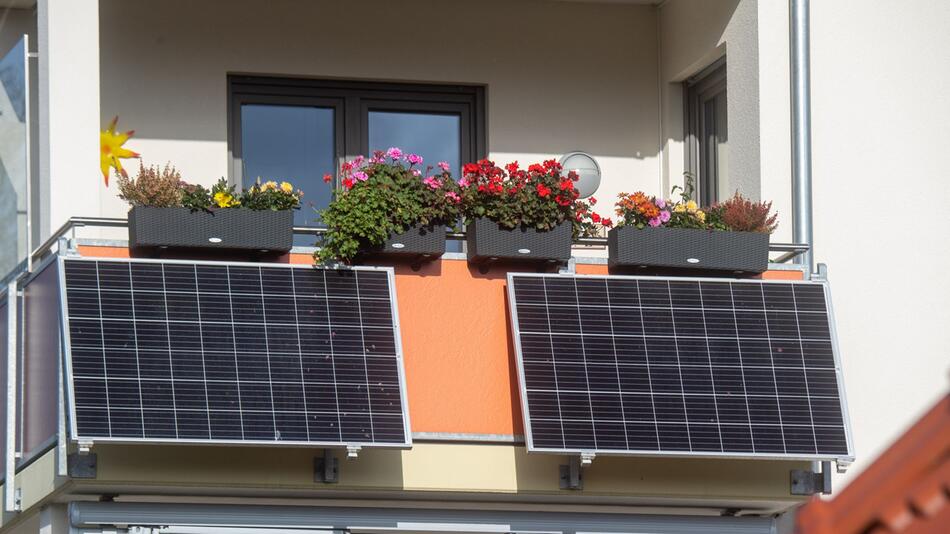 Solarmodule für ein Balkonkraftwerk hängen an einem Balkon