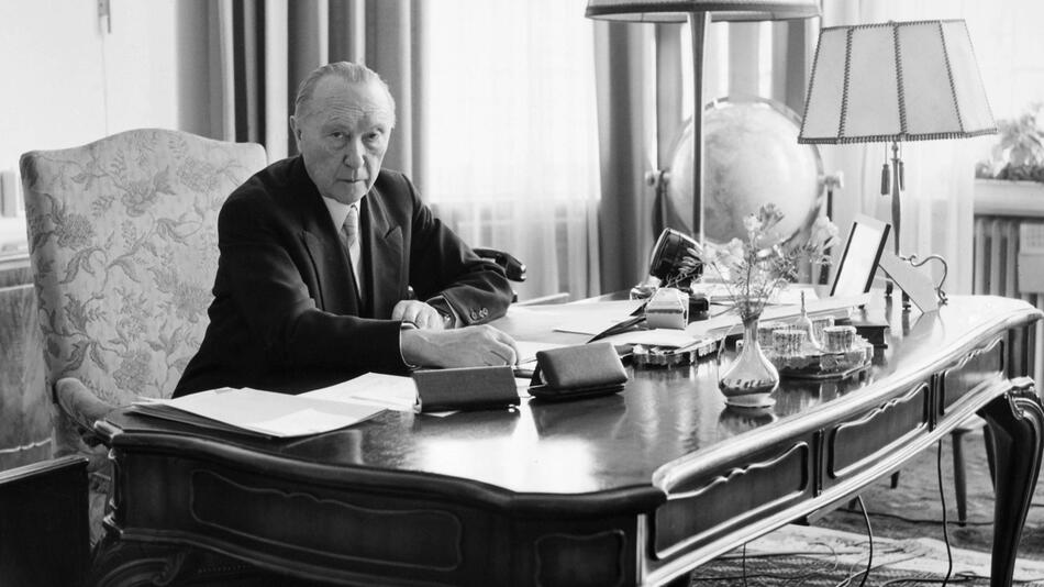 Schwarz-Weiß-Aufnahme von Konrad Adenauer an seinem Schreibtisch im Kanzleramt in Bonn