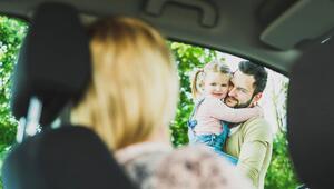 Vater mit Tochter auf dem Arm verabschieden Mutter im Auto