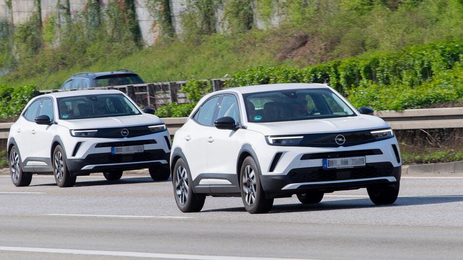 zwei weiße Fahrzeuge, Modell Mokka von Opel