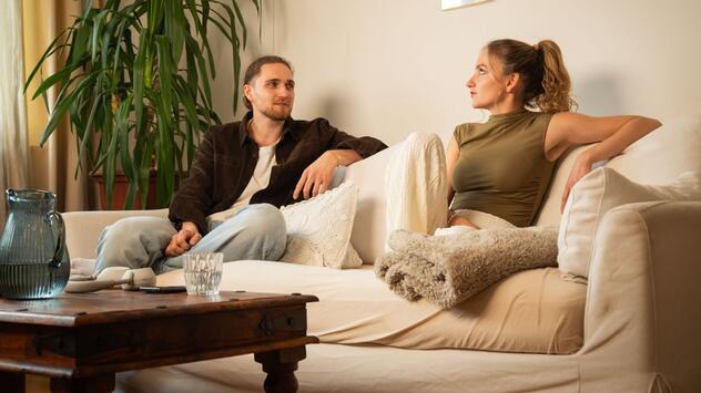 Ein Mann und eine Frau sitzen auf einem Sofa