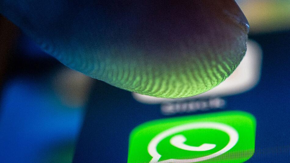 Ein Finger über dem Whatsapp Symbol