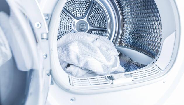 Ein weißes Handtuch liegt in einem Wäschetrockner.