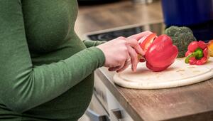 Schwangere Frau kocht mit Gemüse