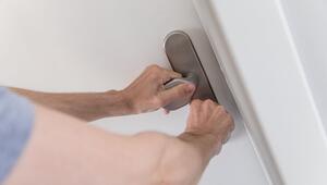 Mann schließt eine Wohnungstür ab