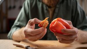 Ein Mann schneidet eine Paprika