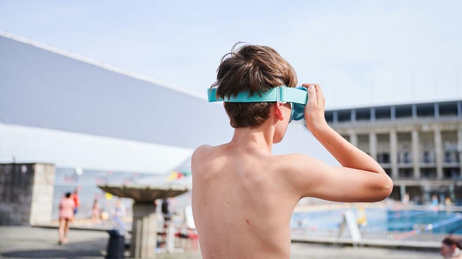 Ein Kind setzt sich seine Schwimmbrille auf