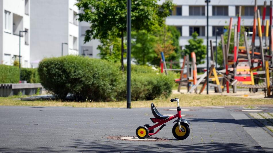 Ein Dreirad für kleine Kinder steht auf einem Innenhof