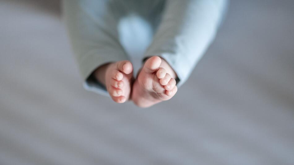 Füße eines Babys sind in einem Kinderbett zu sehen