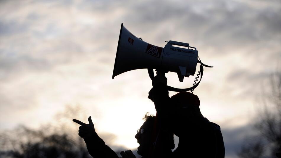 Ein Mann hält ein Megafon bei einem Protest