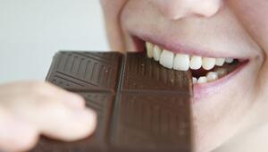 Frau beißt in ein Stück Schokolade