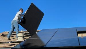 Ein Hausbesitzer baut selbst eine Solaranlage auf.