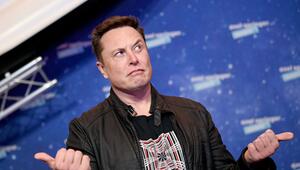 Elon Musk, Chef von SpaceX, guckt fragend vor einer Fotowand