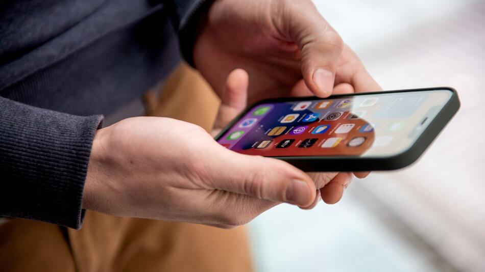 Mann hält ein Smartphone in der Hand