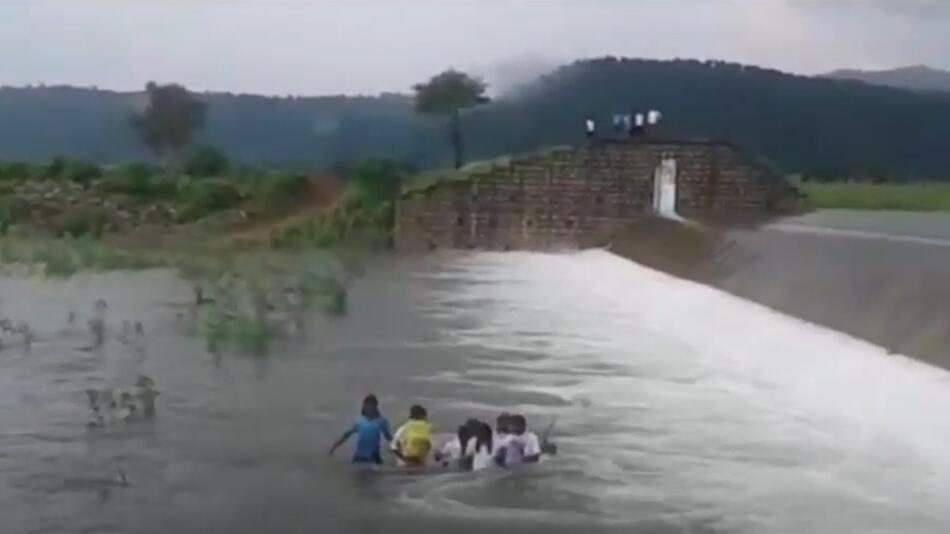 Lebensgefährlicher Schulweg: Indische Schülerinnen waten durch reißenden Fluss