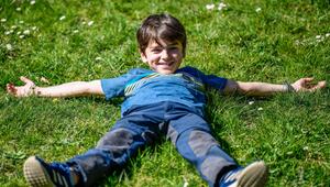 Eine Junge liegt im Gras