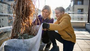 Mutter und Sohn bereiten Balkonpflanzen für den Winter vor