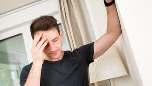 Mann hält sich den schmerzenden Kopf