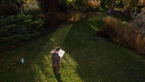 Mann steht in einem Garten, um die Bepflanzung zu planen