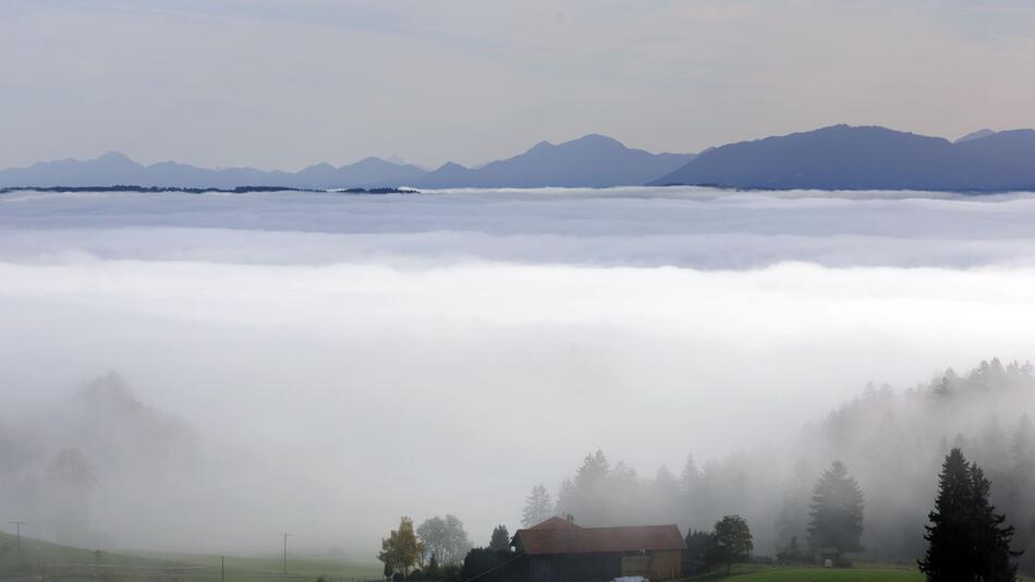 Sonne in den Bergen und Nebel im Tal