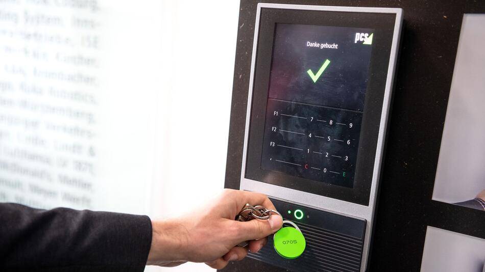 Ein Mitarbeiter erfasst seine Arbeitszeit an einem Terminal