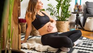 Eine schwangere Frau berührt ihren Babybauch