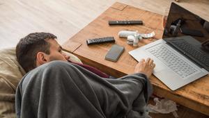 Ein Mann mit Erkältung bedient ein Laptop