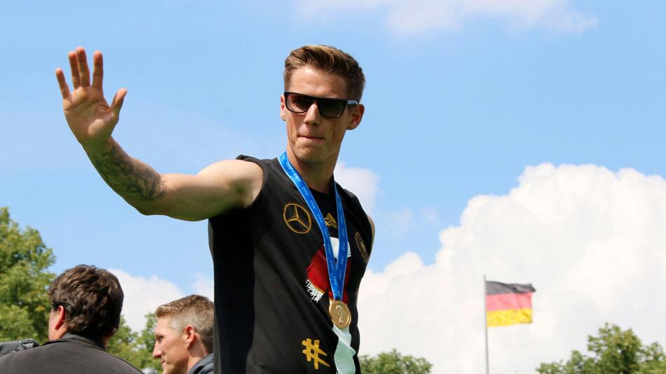 Weltmeister Erik Durm grüßt vor dem Brandenburger Tor ins Publikum
