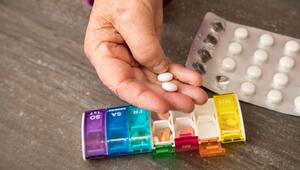 Seniorin nimmt Tabletten aus einer Pillendose