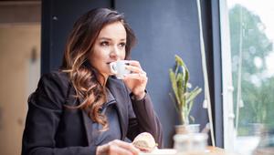Eine Frau trinkt einen Espresso in einem Café
