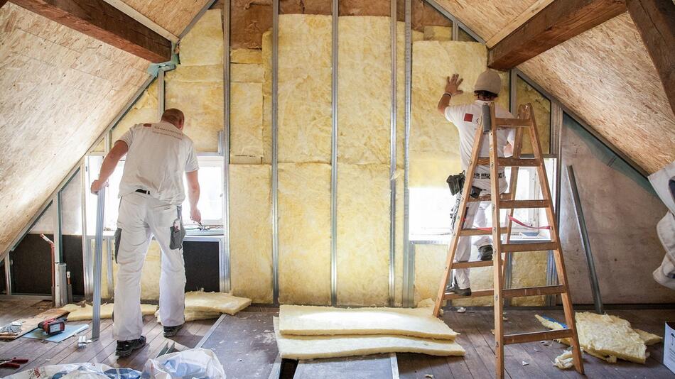 Handwerker dämmen ein Dachgeschoss