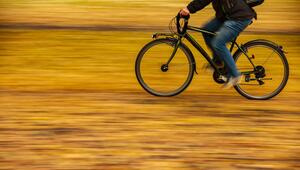 Ein Fahrradfahrer fährt auf einer Straße mit Herbstblättern