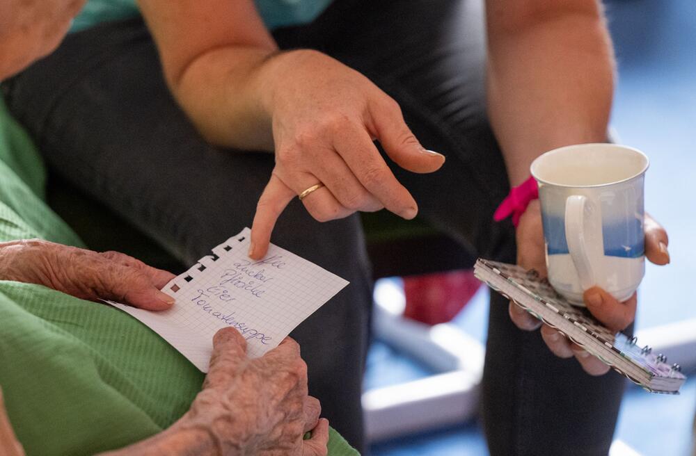 Pflegerin beim Hausbesuch einer pflegebedürftiger Patientin