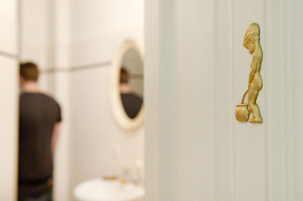 Ein Mann geht auf die Toilette