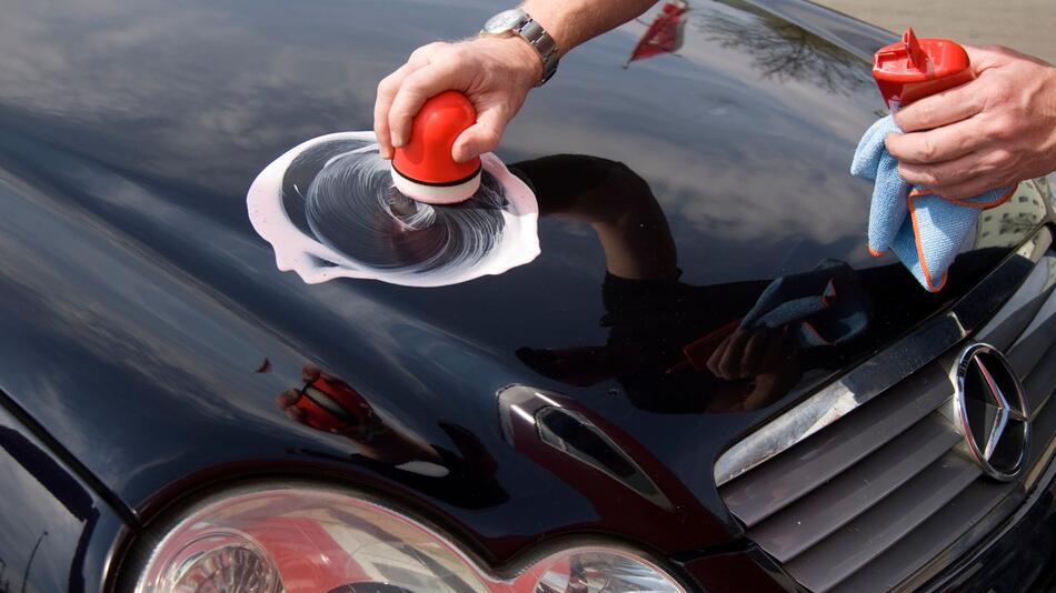 Ein Mann poliert ein Auto