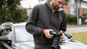 Mann schaut nach dem Fotografieren seines Autos auf Kameradisplay