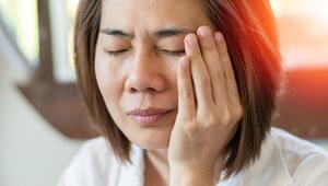 Frau hält sich eine schmerzende Gesichtshälfte