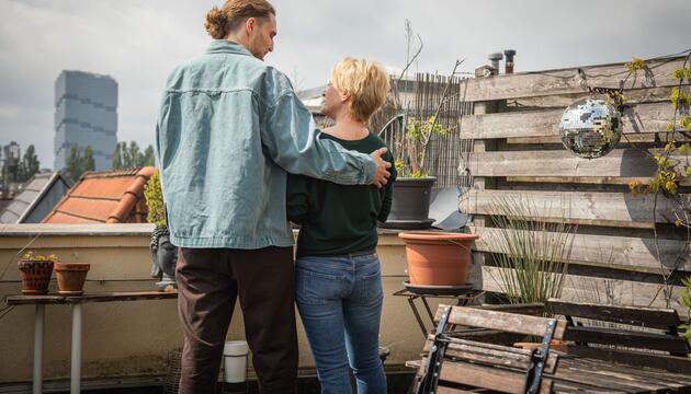 Ein Mann und eine Frau stehen gemeinsam auf einer Terrasse