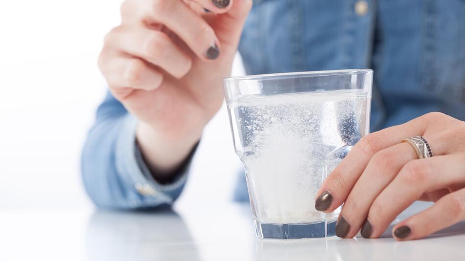 Brausetablette löst sich in einem Glas Wasser auf