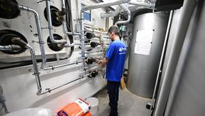 Handwerker arbeitet an Installation der Technik einer Wärmepumpe