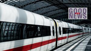 Weißer Hochgeschwindigkeitszug mit rotem Streifen, der in einer modernen Bahnhofshalle mit ...