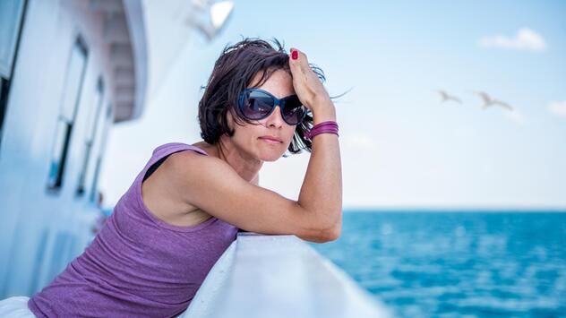 Frau steht auf dem Schiffsdeck