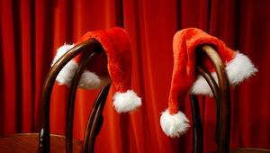 Weihnachtsmützen hängen über Stühlen