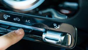 Eine Frau aktiviert die Klimaanlage in einem Auto