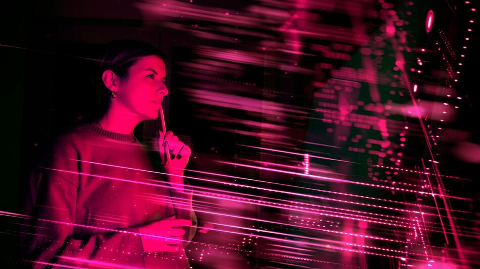 Frau im Neonlicht blickt auf einen digitalen Bildschirm