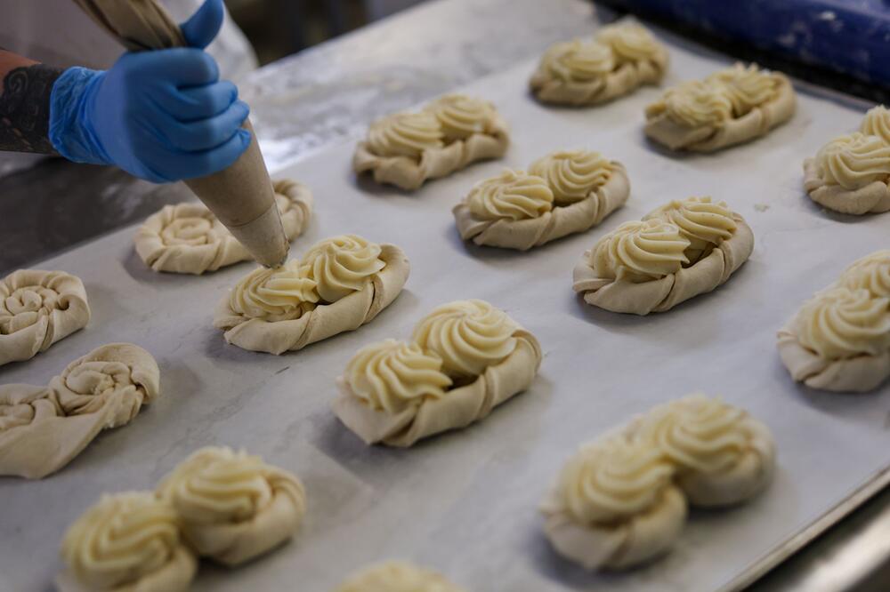 Mitarbeiterin der Bäckerei Lutz füllt Pudding-Brezeln
