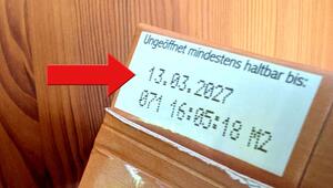 Auf einem braunen Karton befindet sich ein weißes Etikett mit dem Haltbarkeitsdatum "13.03.2027" ...