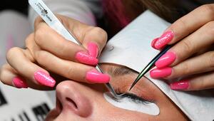 Bei einem Model wird eine Wimpernverlängerung gemacht