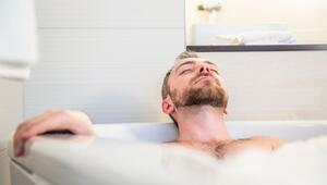 Ein Mann liegt mit geschlossenen Augen in der Badewanne